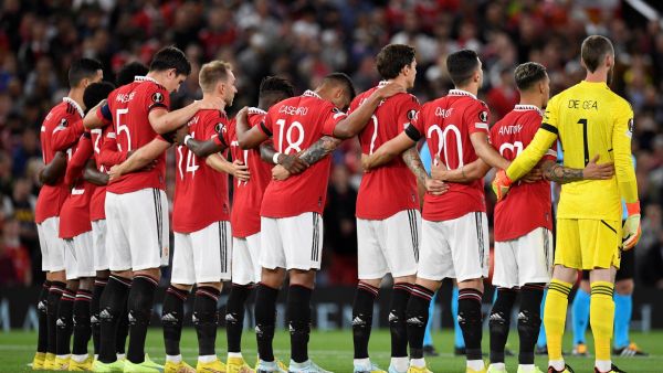 Manchester United players pause for a silence following the death of Queen Elizabeth II, ahead of the UEFA Europa League Group E football match between Manchester United and Real Sociedad, at Old Trafford stadium, in Manchester, on September 8, 2022. (Photo by Oli SCARFF / AFP)