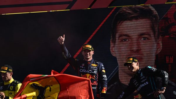 Winner Red Bull Racing's Dutch driver Max Verstappen (C) celebrates with second-placed Ferrari's Monegasque driver Charles Leclerc (L) and third-placed Mercedes' British driver George Russell (R) on the podium after the Italian Formula One Grand Prix at the Autodromo Nazionale circuit in Monza on September 11, 2022. (Photo by Miguel MEDINA / AFP)