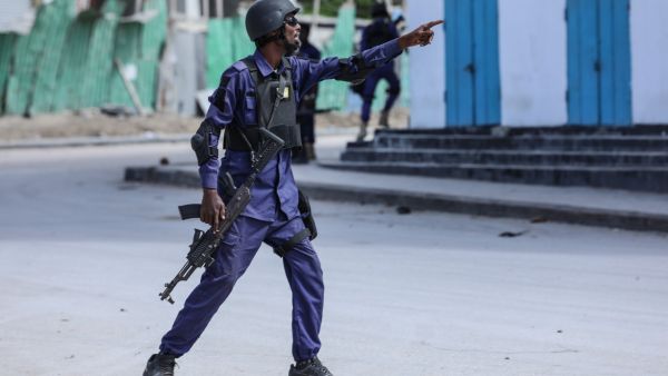 A security officer gestures as he and colleagues patrol at the the site of explosions in Mogadishu on August 20, 2022. (Photo by Hassan Ali ELMI / AFP) Al-Shabab