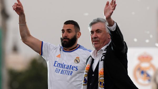 Real Madrid's French forward Karim Benzema (L) and Real Madrid's Italian coach Carlo Ancelotti wave to supporters on the Plaza Cibeles square in Madrid, after Real Madrid CF won the Spanish League football match against RCD Espanyol on April 30, 2022. (Photo by OSCAR DEL POZO / AFP)