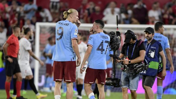 Manchester City's Norwegian striker Erling Haaland (L) speaks with Manchester City's English midfielder Phil Foden at the end of the UEFA Champions League Group G first-leg football match between Sevilla FC and Manchester City, at the Ramon Sanchez Pizjuan stadium in Seville on September 6, 2022. (Photo by CRISTINA QUICLER / AFP)