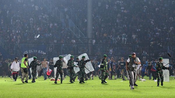 This picture taken on October 1, 2022 shows members of the Indonesian army securing the pitch after a football match between Arema FC and Persebaya Surabaya at Kanjuruhan stadium in Malang, East Java. At least 127 people died at a football stadium in Indonesia late on October 1 when fans invaded the pitch and police responded with tear gas, triggering a stampede, officials said. (Photo by AFP)