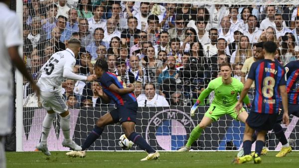 Real Madrid's Uruguayan midfielder Federico Valverde (L) scores his team's second goal during the Spanish League football match between Real Madrid CF and FC Barcelona at the Santiago Bernabeu stadium on October 16, 2022. (Photo by PIERRE-PHILIPPE MARCOU / AFP)