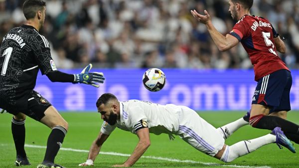 Osasuna's Spanish defender David Garcia (R) reacts after fouling Real Madrid's French forward Karim Benzema (C) during the Spanish League football match between Real Madrid CF and CA Osasuna at the Santiago Bernabeu stadium in Madrid on October 2, 2022. (Photo by JAVIER SORIANO / AFP)