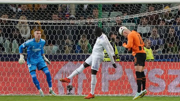 Shakhtar Donetsk's Ukrainian forward Oleksandr Zubkov (R) scores the 1-0 goal as Real Madrid's Ukrainian goalkeeper Andriy Lunin (L) and Real Madrid's French defender Ferland Mendy try to stop him during the UEFA Champions League group F football match Shakhtar Donetsk vs Real Madrid in Warsaw, Poland, on October 11, 2022. (Photo by JANEK SKARZYNSKI / AFP)