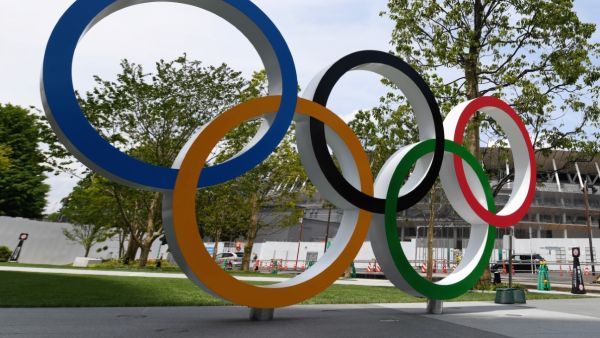 The Olympic Ring displayed at the Japan Sport Olympic Square beside the under constructing national stadium (background) in Tokyo on May 18, 2019. / AFP / Toshifumi KITAMURA