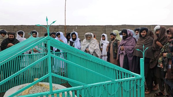 This handout photograph taken on November 6, 2022 and released by the Taliban Government shows the members of the Taliban standing next to the tomb of late Afghan Taliban leader Mullah Omar. (Photo by Taliban Government / AFP) Mullah Omar