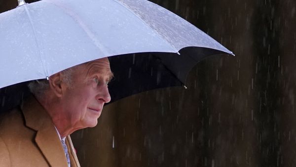 Britain's King Charles III shelters from the rain beneath an umbrella during a visit to York Minster in York, northern England on November 9, 2022 during a two-day tour of Yorkshire. (Photo by Danny Lawson / POOL / AFP) King Charles III