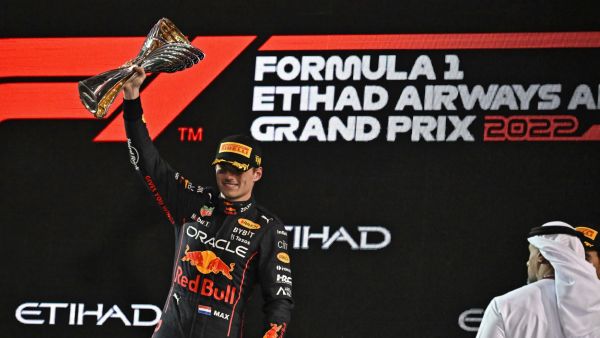 Red Bull's Dutch driver Max Verstappen raises the winner's trophy on the podium after the Abu Dhabi Formula One Grand Prix at the Yas Marina Circuit in the Emirati city of Abu Dhabi on November 20, 2022. (Photo by Ben Stansall / AFP)