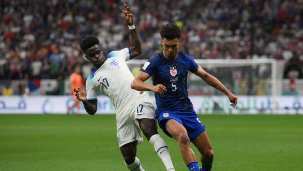 England's forward #17 Bukayo Saka (L) and USA's defender #05 Antonee Robinson fight for the ball during the Qatar 2022 World Cup Group B football match between England and USA at the Al-Bayt Stadium in Al Khor, north of Doha on November 25, 2022. (Photo by Paul ELLIS / AFP)
