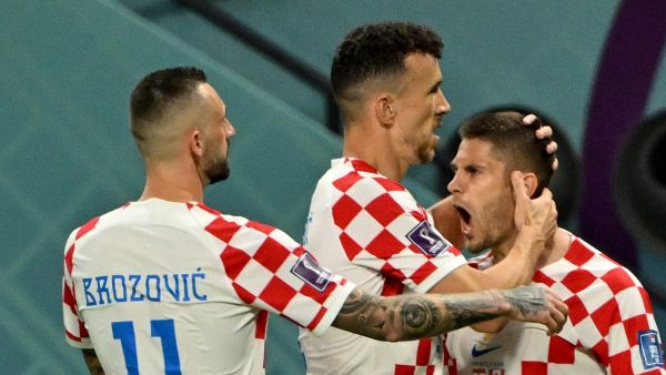 Croatia's forward #09 Andrej Kramaric celebrates with Croatia's midfielder #11 Marcelo Brozovic and Croatia's midfielder #04 Ivan Perisic after scoring his team's first goal during the Qatar 2022 World Cup Group F football match between Croatia and Canada at the Khalifa International Stadium in Doha on November 27, 2022. (Photo by Patrick T. FALLON / AFP)