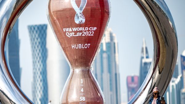 A woman takes pictures in front of the World Cup countdown clock in Doha on November 17, 2022, ahead of the Qatar 2022 World Cup football tournament. (Photo by Philip FONG / AFP)
