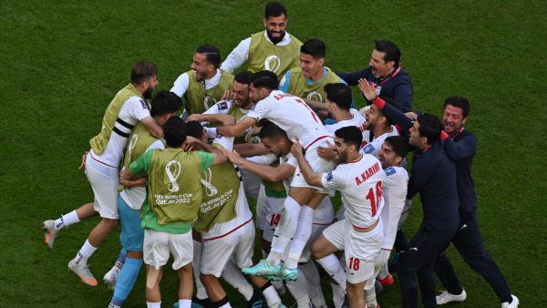 Iran's players celebrate after scoring the opening goal during the Qatar 2022 World Cup Group B football match between Wales and Iran at the Ahmad Bin Ali Stadium in Al-Rayyan, west of Doha on November 25, 2022. (Photo by Antonin THUILLIER / AFP)
