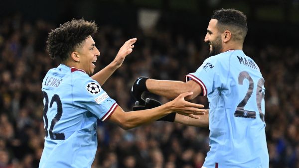 Manchester City's English defender Rico Lewis (L) celebrates scoring his team's first goal with Manchester City's Algerian midfielder Riyad Mahrez (R) during the UEFA Champions League group G football match between Manchester City and Sevilla at the Etihad Stadium in Manchester, north west England on November 2, 2022. (Photo by Oli SCARFF / AFP)