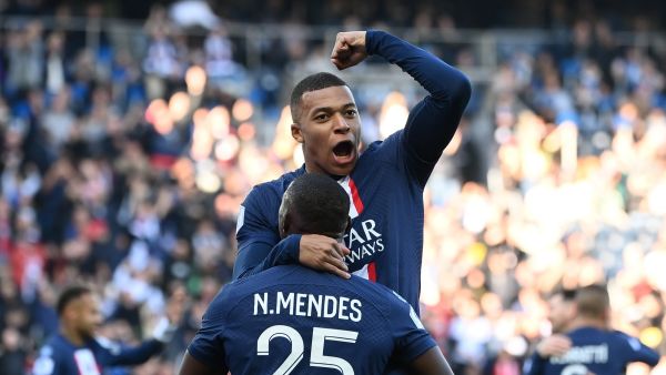 Paris Saint-Germain's French forward Kylian Mbappe (UP) celebrates with Paris Saint-Germain's Portuguese defender Nuno Mendes after scoring his team's first goal during the French L1 football match between Paris Saint-Germain FC and AJ Auxerre at the Parc des Princes stadium in Paris on November 13, 2022. (Photo by FRANCK FIFE / AFP)