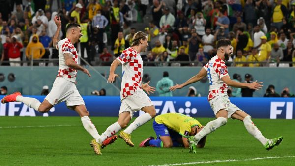 Croatia players celebrate past Brazil's defender #04 Marquinhos (C) after they won on penalty shoot-out the Qatar 2022 World Cup quarter-final football match between Croatia and Brazil at Education City Stadium in Al-Rayyan, west of Doha, on December 9, 2022. (Photo by NELSON ALMEIDA / AFP)