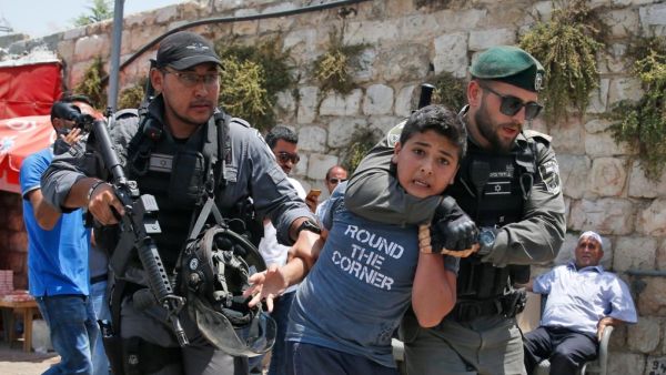 An Israeli soldier arresting a Palestinian youth 