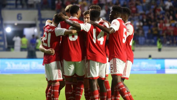 Arsenal's players gather in a huddle as they celebrate scoring during the AC Milan and Arsenal friendly match at the Dubai Super Cup 2022, at the al-Maktoum stadium in the Gulf emirate, on December 13, 2022. (Photo by KARIM SAHIB / AFP)
