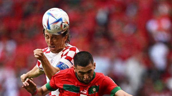 Croatia's midfielder #10 Luka Modric and Morocco's midfielder #07 Hakim Ziyech jump for a header during the Qatar 2022 World Cup Group F football match between Morocco and Croatia at the Al-Bayt Stadium in Al Khor, north of Doha on November 23, 2022. (Photo by MANAN VATSYAYANA / AFP)