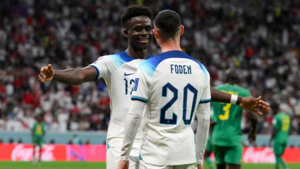 England's forward #17 Bukayo Saka celebrates with England's forward #20 Phil Foden after scoring his team's third goal during the Qatar 2022 World Cup round of 16 football match between England and Senegal at the Al-Bayt Stadium in Al Khor, north of Doha on December 4, 2022. (Photo by Paul ELLIS / AFP)