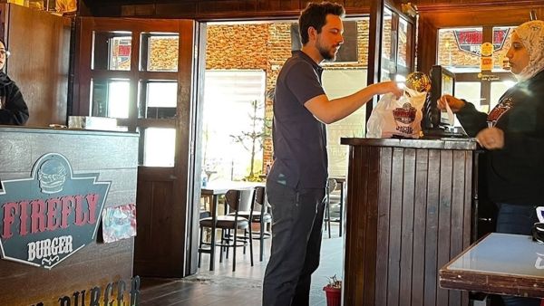 ولي العهد الأردني يستلم طلبه من المطعم (فيس بوك)