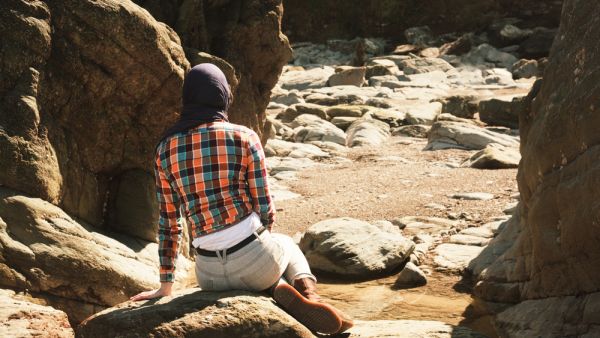 فتاة تجلس على الصخور في مدينة البتراء الاثرية جنوب الاردن