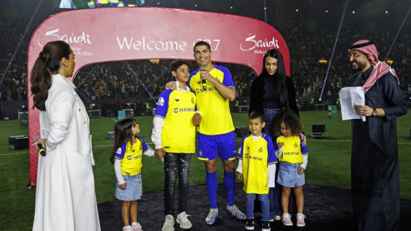 Al-Nassr's new Portuguese forward Cristiano Ronaldo (C) alongside his partner Georgina Rodriguez (C-R) and their children standing on the stage during his unveiling at the Mrsool Park Stadium. (Photo by Jorge Ferrari / Al Nassr Football Club / AFP)  Cristiano Ronaldo