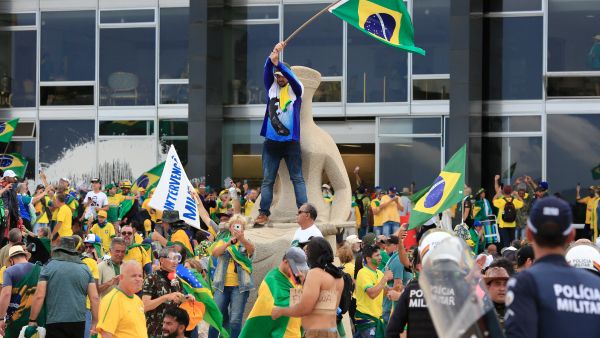 Supporters of Brazilian former President Jair Bolsonaro invade Planalto Presidential Palace while clashing with security forces in Brasilia on January 8, 2023. (Photo by Sergio Lima / AFP) Capitol riots
