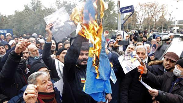 Iranians burn a Swedish flag during a protest