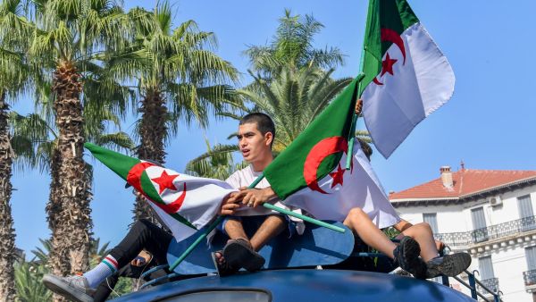 شبان جزائريون يرفعون علم بلادهم (أ ف ب)