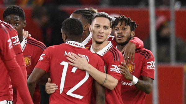 Manchester United's Brazilian midfielder Antony (C) celebrates with teammates after scoring the opening goal of the English League Cup quarter final football match between Manchester United and Charlton Athletic, at Old Trafford, in Manchester, north-west England on January 10, 2023. (Photo by Oli SCARFF / AFP)
