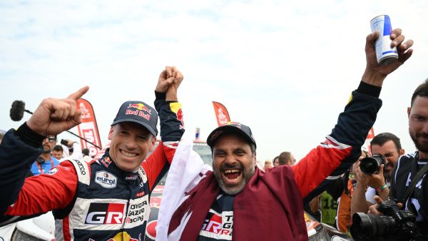 Toyota's driver Nasser Al-Attiyah (R) of Qatar and his co-driver Mathieu Baumel of France celebrate their victory after winning the Dakar Rally 2023, at the end of the last stage between between Al-Hofuf and Dammam, Saudi Arabia, on January 15, 2023. Qatari driver Nasser Al-Attiyah won his fifth Dakar Rally driver's title and second in a row today after the iconic test of endurance finished in Dammam, Saudi Arabia. (Photo by FRANCK FIFE / AFP)