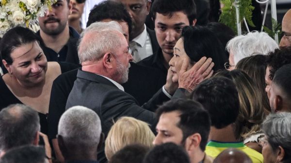 Brazil's President Luiz Inacio Lula da Silva (L) greets the wife of Brazilian football legend Pele, Marcia Aoki (R), during his wake at the Urbano Caldeira stadium in Santos, Sao Paulo state, Brazil on January 3, 2023. Brazilian President Luiz Inacio Lula da Silva paid his last respects Tuesday to football legend Pele, attending his wake in the southeastern city of Santos, where the icon first dazzled the world with his talent. (Photo by NELSON ALMEIDA / AFP)