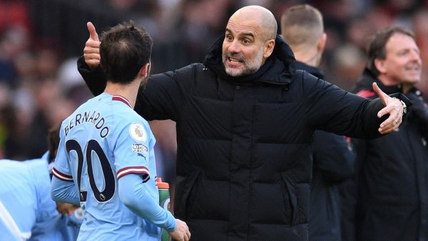 Manchester City's Spanish manager Pep Guardiola (C) reacts as he talks with Manchester City's Portuguese midfielder Bernardo Silva (L) during the English Premier League football match between Manchester United and Manchester City at Old Trafford in Manchester, north west England, on January 14, 2023. (Photo by Oli SCARFF / AFP)