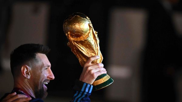 Argentina's captain and forward Lionel Messi holds the FIFA World Cup Trophy upon arrival at Ezeiza International Airport after winning the Qatar 2022 World Cup tournament in Ezeiza, Buenos Aires province, Argentina on December 20, 2022. (Photo by Luis ROBAYO / AFP)