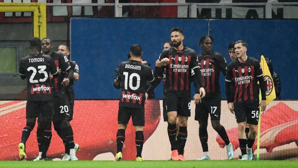 AC Milan's French defender Pierre Kalulu (2L) celebrates with teammates after opening the scoring during the Italian Serie A football match between AC Milan and AS Roma, at the San Siro stadium in Milan, on January 8, 2023. (Photo by Filippo MONTEFORTE / AFP)