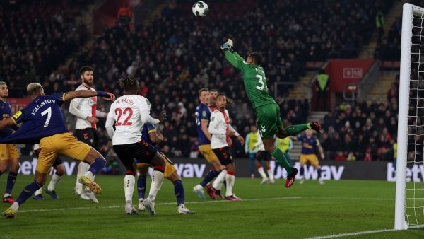 Southampton's Irish goalkeeper Gavin Bazunu (R) jumps to punch the ball away whilst making a save during the English League Cup semi-final first-leg football match between Southampton and Newcastle United at St Mary's Stadium in Southampton, southern England on January 24, 2023. (Photo by ADRIAN DENNIS / AFP)