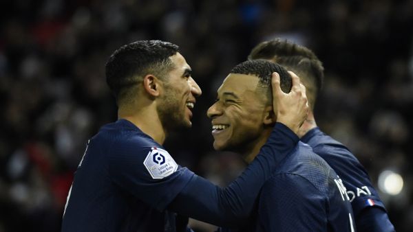 Paris Saint-Germain's French forward Kylian Mbappe (C) celebrates after scoring a penalty with Paris Saint-Germain's Moroccan defender Achraf Hakimi (L) during the French L1 football match between Paris Saint-Germain FC and RC Strasbourg Alsace at The Parc des Princes stadium in Paris on December 28, 2022. (Photo by JULIEN DE ROSA / AFP)