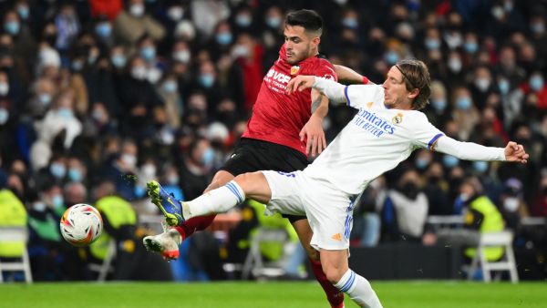 Valencia's Spanish defender Hugo Guillamon (L) vies with Real Madrid's Croatian midfielder Luka Modric during the Spanish league football match between Real Madrid CF and Valencia CF at the Santiago Bernabeu stadium in Madrid on January 8, 2022. (Photo by GABRIEL BOUYS / AFP)