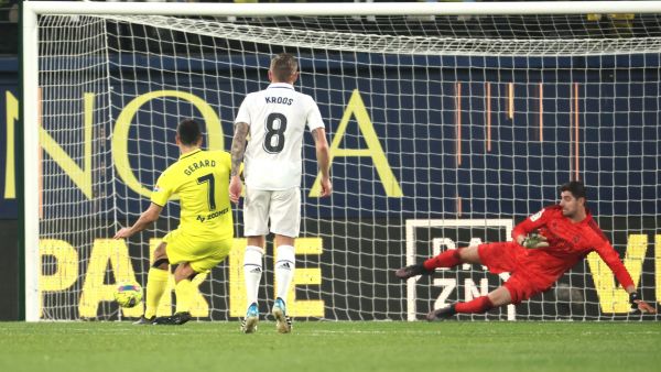 Villarreal's Spanish forward Gerard Moreno scores a goal in spite of Real Madrid's Belgian goalkeeper Thibaut Courtois (R) during the Spanish League football match between Villarreal CF and Real Madrid CF at La Ceramica stadium in Villarreal on January 7, 2023. (Photo by JOSE JORDAN / AFP)