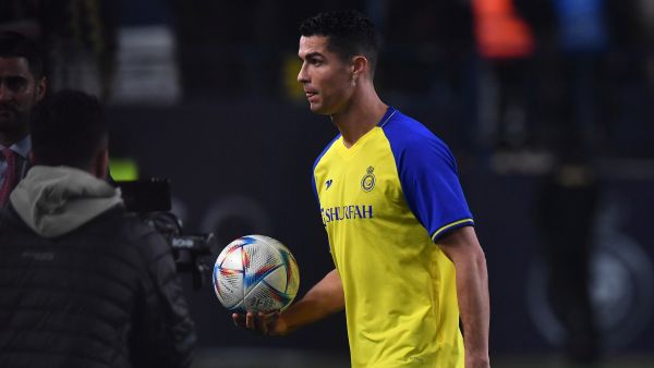 Al-Nassr's new Portuguese forward Cristiano Ronaldo carries a ball he autographed, to give the fans, during his unveiling at the Mrsool Park Stadium in the Saudi capital Riyadh on January 3, 2023. (Photo by AFP)