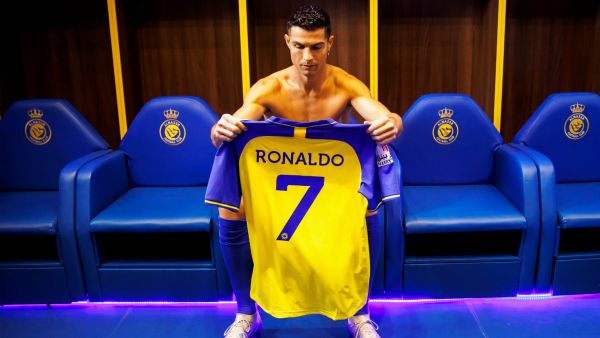 A handout picture released by Saudi Arabia's al-Nassr football club shows Al-Nassr's new Portuguese forward Cristiano Ronaldo holding the club's number seven jersey ahead of his unveiling ceremony at the Mrsool Park Stadium in the Saudi capital Riyadh on January 3, 2023. (Photo by Jorge Ferrari / Al Nassr Football Club / AFP)