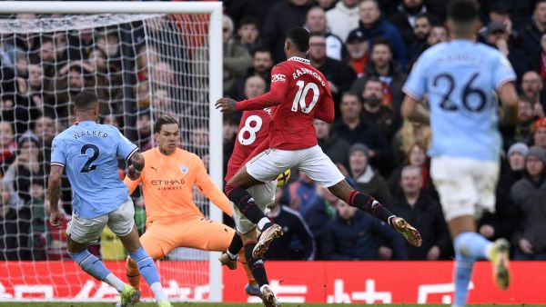 Manchester United's English striker Marcus Rashford (R) watches as Manchester United's Portuguese midfielder Bruno Fernandes (C) scores the equalising goal past Manchester City's Brazilian goalkeeper Ederson during the English Premier League football match between Manchester United and Manchester City at Old Trafford in Manchester, north west England, on January 14, 2023. (Photo by Oli SCARFF / AFP)