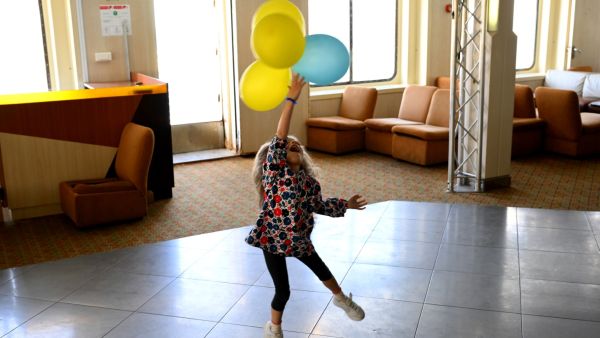 A Ukrainian girl plays with balloons with the colours of her country's flag aboard the Corsica Linea ferry "Mediterranee" in Marseille, southern France, on April 26, 2022. (Photo by Nicolas TUCAT / AFP) Ukrainian refugees