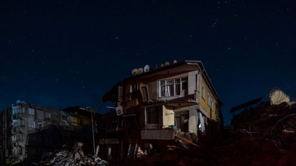 This photograph shows a partially damaged building in Antakya, southern Turkey on February 20, 2023, after a 6,4-magnitude second earthquake hit the Hatay province in southern Turkey, in Antakya. (Photo by Sameer Al-DOUMY / AFP) blue lightning