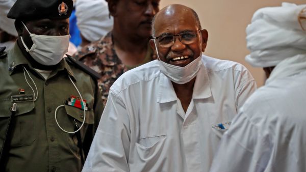 الرئيس السوداني المخلوع عمر البشير يبتسم خلال محاكمته في الخرطوم 