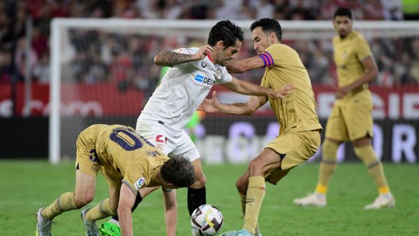 Sevilla's Spanish midfielder Isco (C) fights for the ball with Barcelona's Spanish midfielder Gavi (L) and Barcelona's Spanish midfielder Sergio Busquets during the Spanish league football match between Sevilla FC and FC Barcelona at the Ramon Sanchez Pizjuan stadium in Seville, on September 2, 2022. (Photo by CRISTINA QUICLER / AFP)