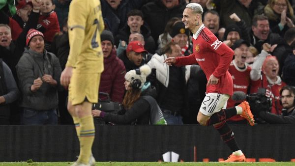 Manchester United's Brazilian midfielder Antony (R) celebrates after scoring his team second goal during the UEFA Europa league knockout round play-off second leg football match between Manchester United and FC Barcelona at Old Trafford stadium in Manchester, north west England, on February 23, 2023. (Photo by Oli SCARFF / AFP)
