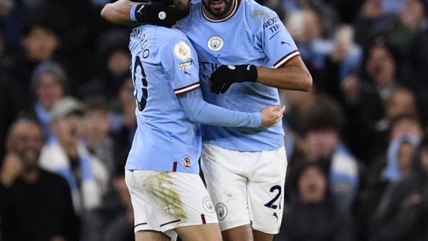 Manchester City's Algerian midfielder Riyad Mahrez (R) celebrates scoring the team's fourth goal during the English Premier League football match between Manchester City and Tottenham Hotspur at the Etihad Stadium in Manchester, north west England, on January 19, 2023. (Photo by Oli SCARFF / AFP)