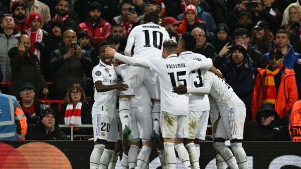 Real Madrid's French forward Karim Benzema is mobbed by teammates after scoring the team's fourth goal during the UEFA Champions League last 16 first leg football match between Liverpool and Real Madrid at Anfield in Liverpool, north west England on February 21, 2023. (Photo by Paul ELLIS / AFP) 